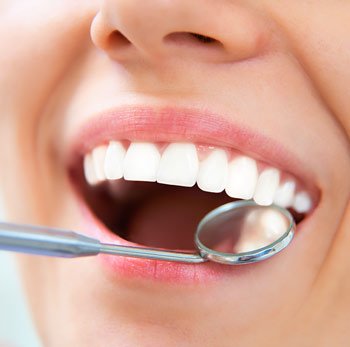 dental mirror reflecting mouth smiling with nice white teeth, cosmetic dentist Marlboro, NJ