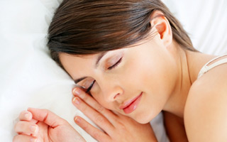 woman sleeping with head against pillow, dental night guards San Diego, CA dentist